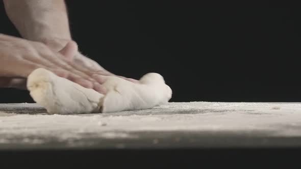 Male Hands Divide Baking Dough Into Shares on a Board Sprinkled with Flour alt