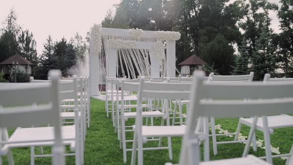 beautiful wedding arch in the park with white chairs