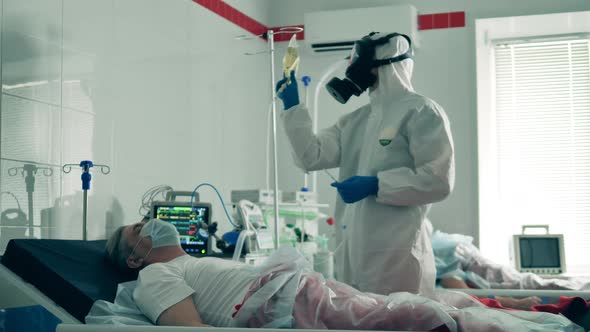 Coronavirus, Covid-19 Patient in Intensive Care Unit at a Hospital. Hospital Worker Gives a Patient alt