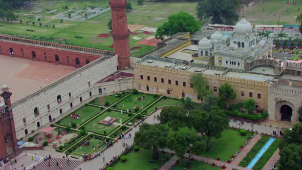 Drone flight to the Sikhism Temple (Gurdwara) passing over a Mosque, Children and ladies waving at t alt