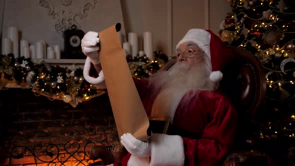 Santa Claus Reading Letter with List Gifts From Children for Christmas Holidays alt