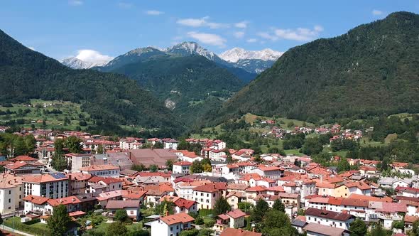 Aerial drone shot of the town of Tolmin in Slovenia with a mountain range backdrop.
