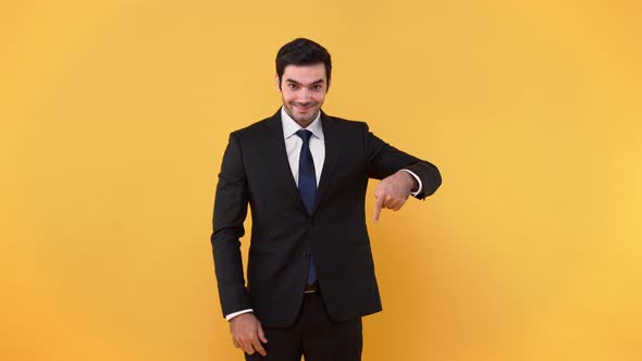 Friendly handsome man in formal business suit pointing hands downwards to empty space