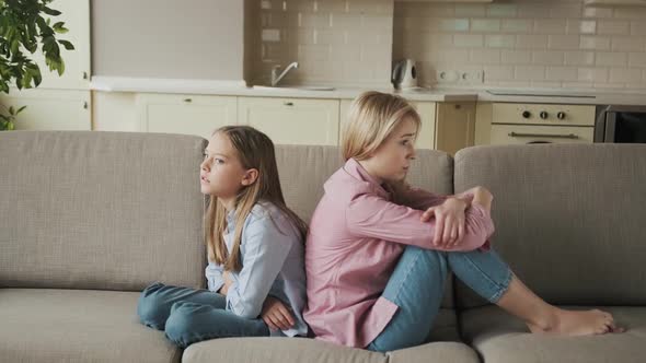 Angry Mother and Little Child Girl Sitting Back to Back on Sofa Not Talking After Fight Stubborn Kid alt