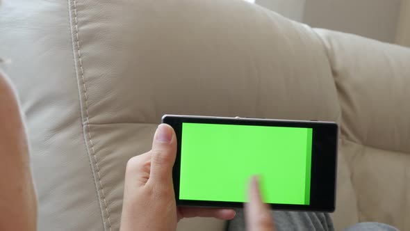 Green screen touch screen mobile phone in woman hands and scrolling pages 4K 2160p 30fps UltraHD foo alt