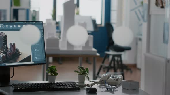 Empty Architectural Workplace with Building Model and 3d Construction Layout on Table alt