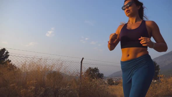 Following to Sporty Girl Jogging in Country Road at Sunrise alt
