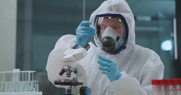 Virologist Is Researching Danger Virus in Laboratory, Man Is Dressed Protective Overall and Face alt