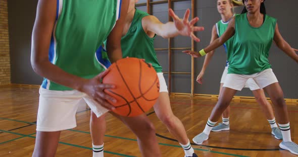 Diverse female basketball team playing match, dribbling and shooting ball alt