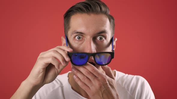 Stylish Young Man Shocked and Surprised on Red Color Background