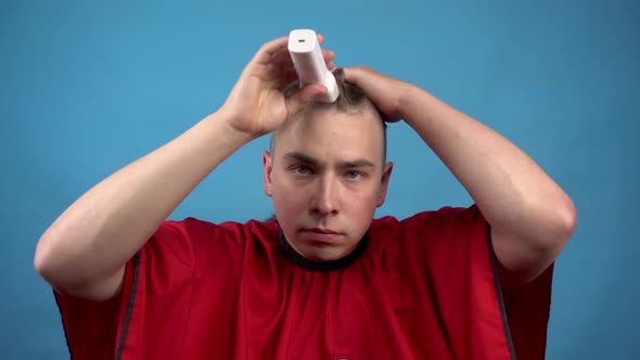 A Young Man Cuts Himself Baldly. A Man Uses a Hairdressing Machine Cuts His Hair. alt
