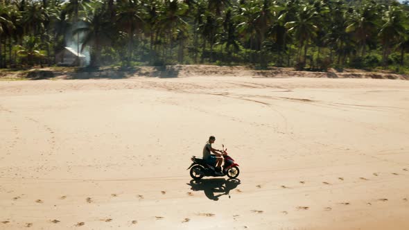 Man Driving a Motorcycle on Beach alt