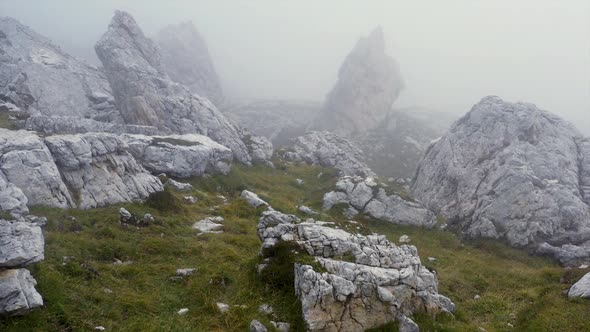 Drone flight over the foggy rocks of the Dolomites