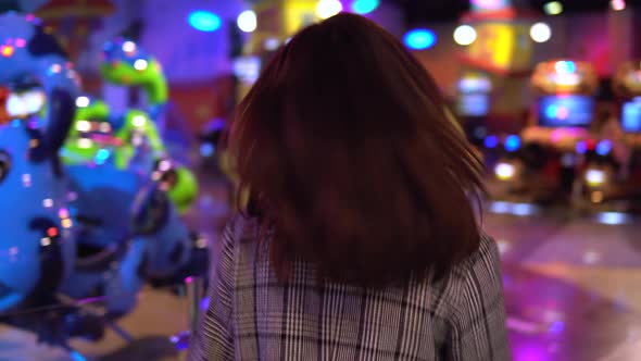 A Young Woman Is Walking in an Amusement Park. The Camera Follows the Girl. Park for Children with alt
