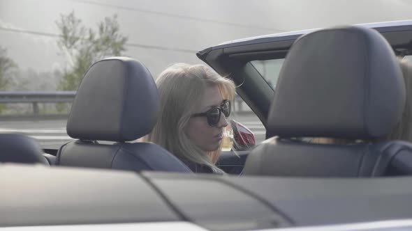 Two Girls Talking Into Red Cabriolet. American Girls Enjoying Summer Vacation.