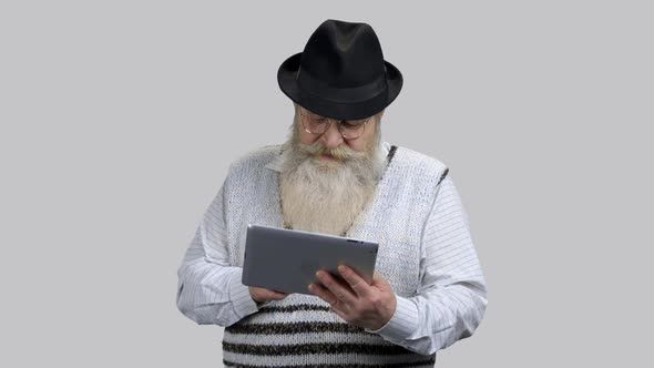 Old Retired Grandpa Surfing the Internet Using Tablet Pc alt