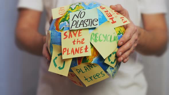 Man Hands Hold Earth Globe with Stickers alt