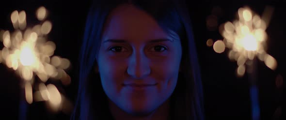 Woman opening her eyes and smiling with two sparkles in the background alt