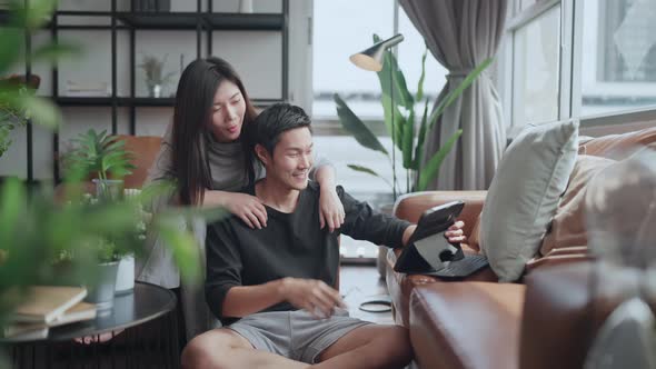 asian marry couple sit relax using laptop and tablet social media or shopping online