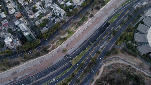 Aerial top down dolly in of Mapocho river and cars driving in avenues and highway and Santiago city alt