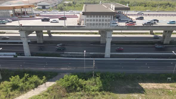 Tracking shot along Toll Gateway on Highway, Vehicles driving road Underneath. alt