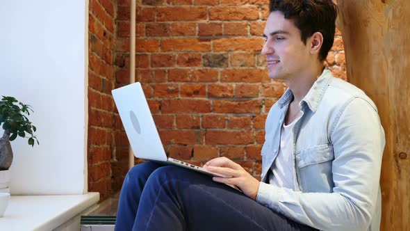 Web Video Chat on Laptop by Young Man, Sitting on Stairs alt
