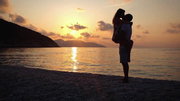 Happy family having a fun at beach at sunset over the sea. Slow molion footage