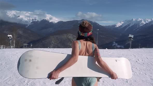 Sexy Asian Woman in Blue Swimsuit Run at Winter Ski Resort at Snowy Sunny Day alt