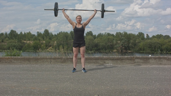 Female athlete doing crossfit deadlifts outdoors