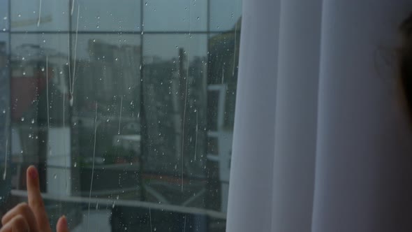 Shooting Raindrops on the Window on Which the Girl Runs Her Fingers