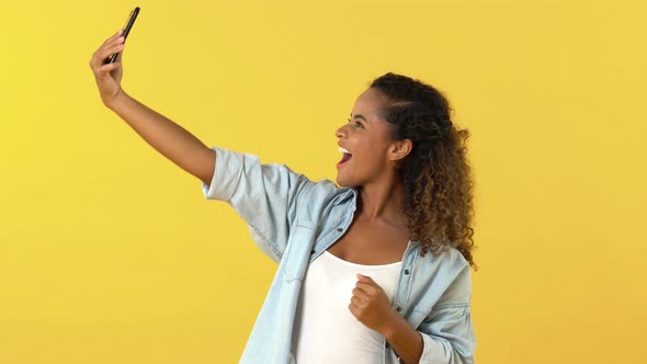 Excited African American woman smiling and waving bye while having video call