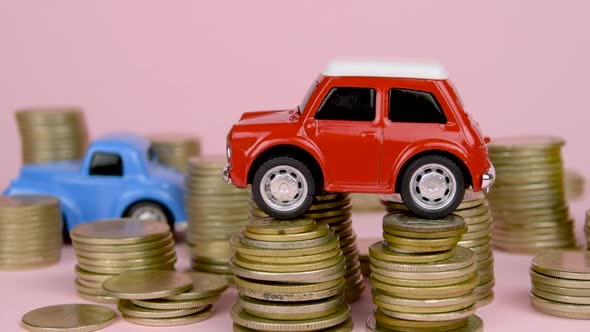 Cars Among Coins Car On Pile Of Coins Stacks Of Coins Around It Pink Background
