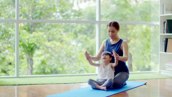 Young mother teaching her cute daughter for exercise