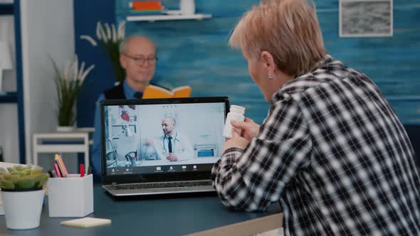 Young Male Doctor Talking to Senior Female Patient By Tele Medicine Online alt