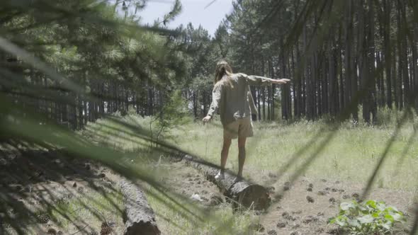 Woman walking on fallen log