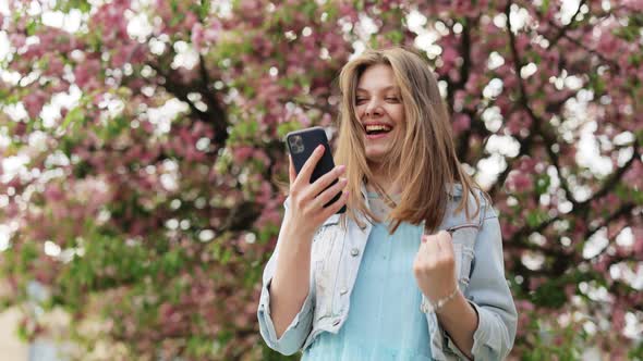 Portrait of Happy Woman Enjoy Success on Mobile Phone