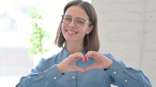 Portrait of Young Woman showing Heart Sign by Hand alt