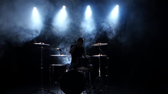 Energetic Musician Plays Good Music on Drums. Black Smoky Background, Back Light, Silhouette alt