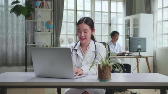 Young Asian Woman Doctor Is Using Laptop In Workplace. Medical Concept
