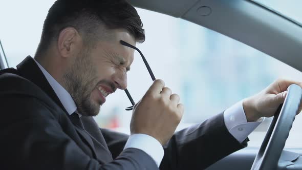 Distressed Man Suffering Bad Headache in Car, Result of Stressful Job Overwork