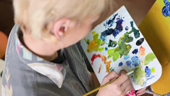 Female Artist Mixes Paints on the Palette Painter at the Studio Creator Makes Piece of Art alt