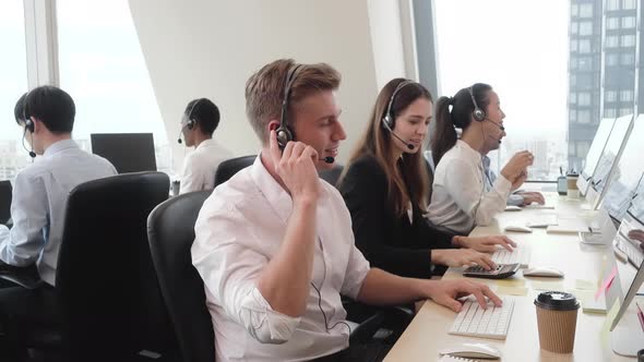 Group of diverse people wearing microphone headset working in call center office