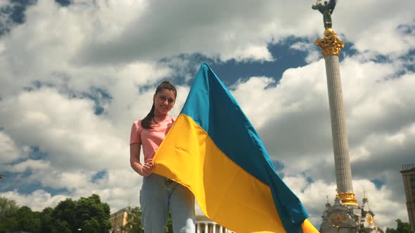 Young Woman with National Flag of Ukraine on the Street alt