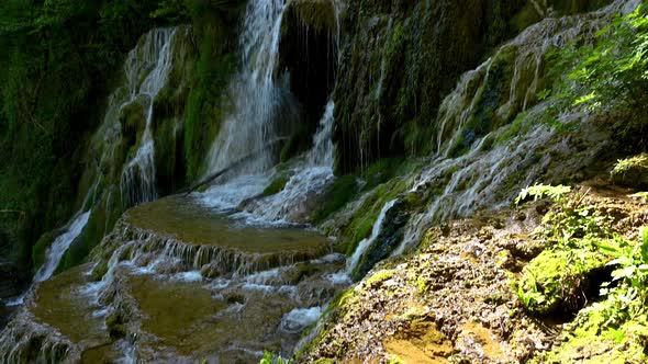 Video with a beautiful waterfall in green spring forest alt