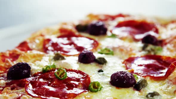 Baked pizza with avocado, cherry tomato and olive toppings alt