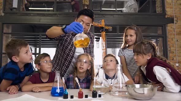 Scientist Showing Kids how to do Chemical Reaction Experiments in Lab Class alt