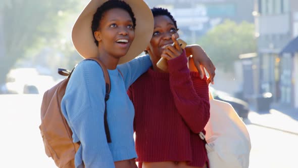 Front view of African American twin sisters standing on street in the city 4k alt