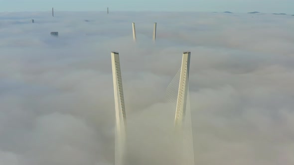 Tops of the Pylons of the Golden Bridge in the Dawn Fog in Vladivostok alt