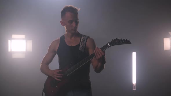 Cool Pumped-up Rock Guitarist in Black T-shirt Performs on Stage and Performs Solo Number on alt