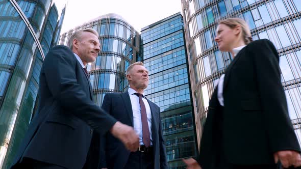Low Angle, Hiring Young Motivated Woman for a Project, Two Businessmen Negotiators Wear Suits Shake